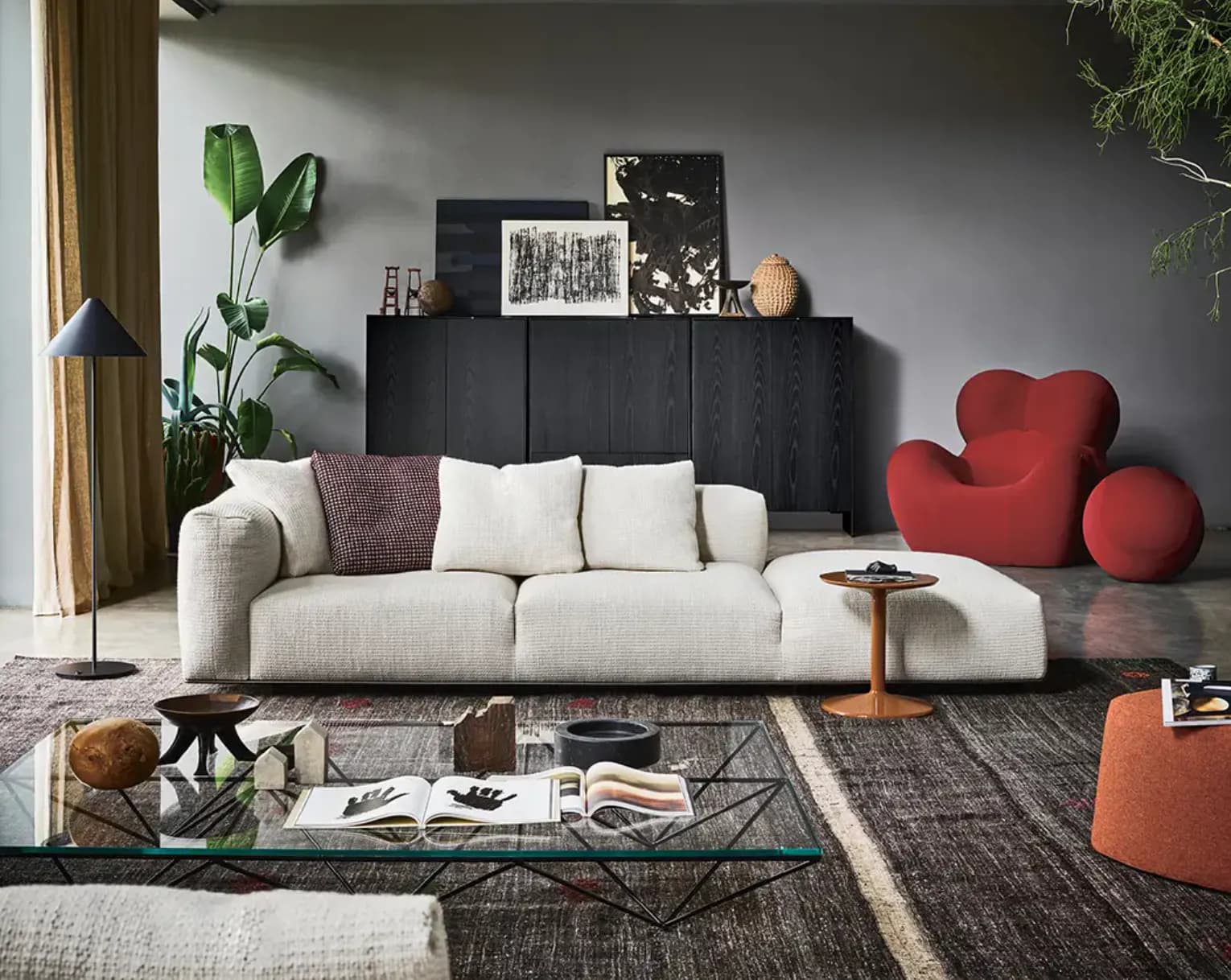 Phòng khách với sofa trắng, tủ đen và ghế lounge đỏ